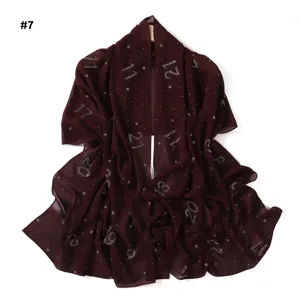 Vista dettagliata del foulard hijab in chiffon bordeaux con numeri in strass brillanti e leggeri.