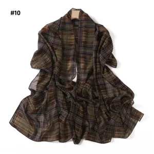 Detail view of the elegant brown and green plaid chiffon scarf hanging on display.