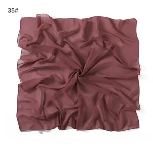 Detail view of solid color dark red chiffon square scarf, soft lightweight fabric and rolled hem.