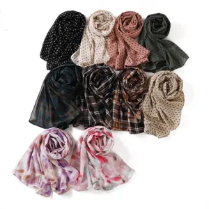 Close-up of printed chiffon headscarves, featuring colorful polka dots and classic plaid designs.