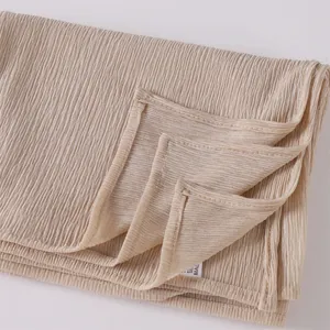 Detailed view of the pleated beige jersey hijab fabric, showing texture and neat stitching.