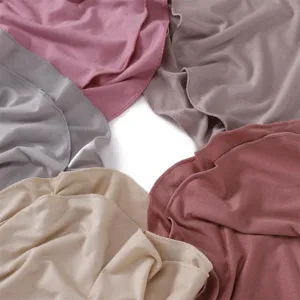 Dettagli di colore in tessuto modal con texture morbida e tonalità unite per accessori.