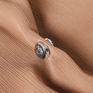 Vista di dettaglio di una fibbia magnetica rotonda per sciarpa con motivo a tulipano.