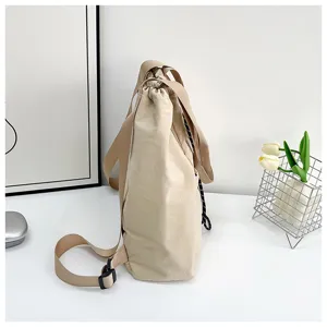Detail shot of a casual solid color canvas drawstring backpack with adjustable straps.