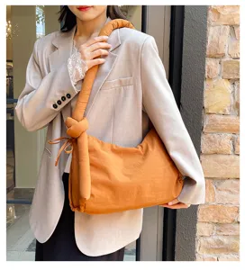 Detail view of the soft padded shoulder bag showing the unique knotted strap and side drawstring.