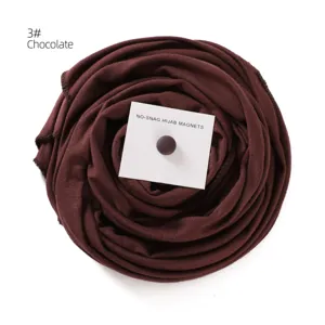 Detailed view of dark brown hijab scarf with matching magnetic pin for secure styling.