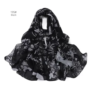 Dettaglio di sciarpa in chiffon nero, motivo stampato floreale e uccello, tessuto leggero.