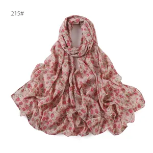 Vista di dettaglio della sciarpa in chiffon a fiori, tessuto rosa delicato con piccoli motivi.