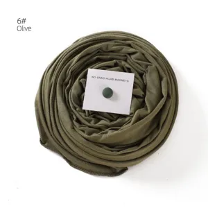 Detail view of olive green mercerized cotton hijab scarf paired with a magnetic pin accessory