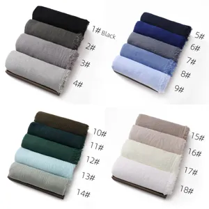 Solid color cotton linen scarf shawl detail showing multi-color variant rolls with fringe.