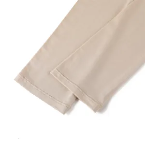 Détail rapproché de manchons de protection solaire couleur chair en tissu extensible.