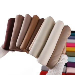 Detailed view of soft modal jersey hijab scarves in various earth tones held neatly.