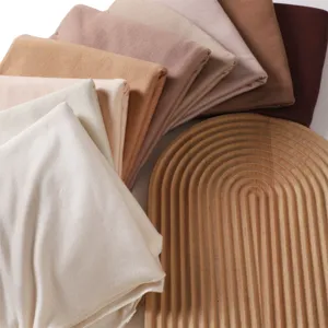 Detail shot of soft solid color modal jersey scarves stacked in gradient earth tones.