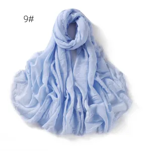 Light blue crinkled gauze scarf detail, breathable linen shawl with delicate fringe.