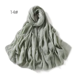 Detail view of light green linen gauze scarf shawl showing soft texture and fringe edge.