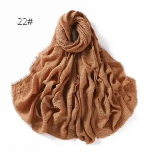 Detailed view of brown crinkled cotton linen scarf showing soft texture and fringe edge.