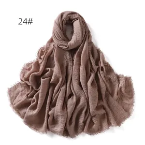 Close-up detail of the soft crinkled cotton linen scarf showing the delicate fringe edge.
