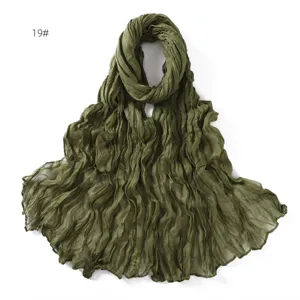 Detail view of olive green crinkled cotton linen scarf, lightweight breathable fabric.