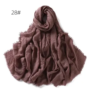 Solid color cotton linen scarf detail showing soft textured fabric and delicate fringe edge.