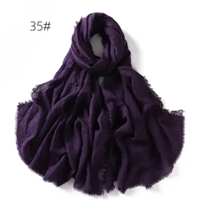 Close-up of deep purple crinkled cotton linen scarf, showing soft breathable fabric and tassels.