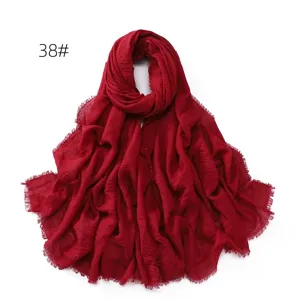 Solid color cotton linen scarf detail showing breathable texture and delicate fringe edge.