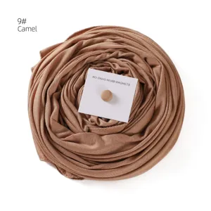 Detail view of the mercerized cotton long hijab scarf in camel with magnetic buckle set.