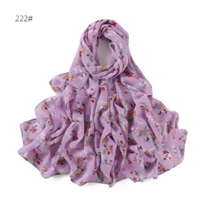 Vista dettagliata della sciarpa lunga in chiffon lilla chiaro con motivo floreale e drappeggio.
