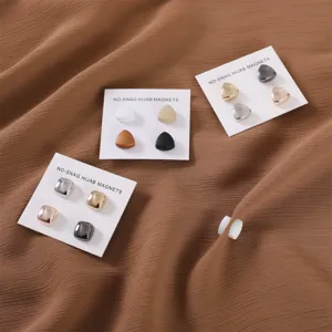 Gedetailleerd uitzicht op kleurrijke magnetische hijabbespeltjes en sjaalclips op kaartjes.