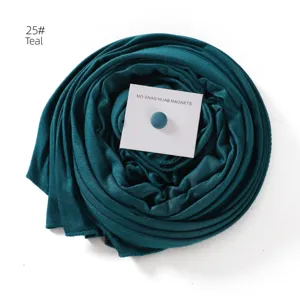 Teal hijab scarf with magnet pin detail, soft mercerized cotton texture, elegant wrapped presentation