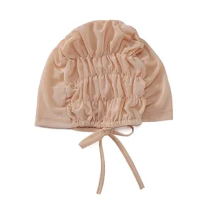 Close-up of beige mesh inner cap featuring delicate ruching and adjustable drawstring ties.