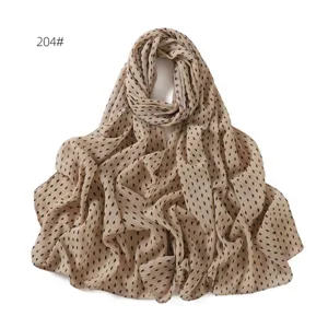 Detail view of a beige chiffon hijab scarf featuring a chic black diamond dot pattern design.