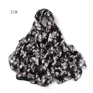 Close-up detail of black floral chiffon scarf, lightweight spring and summer sun protection.