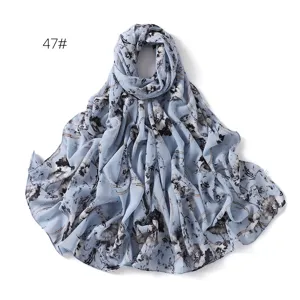 Detailed view of the light blue floral chiffon scarf, elegant print fabric texture.