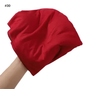 Detailed view of soft red jersey modal scarf fabric, breathable textile turban closeup.