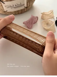 Primer plano detallado de la banda para el cabello elástica y calada con textura de malla.