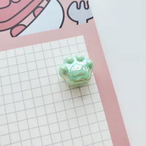 Close-up detail of shiny green AB acrylic cat paw bead, perfect for DIY jewelry crafting items.