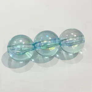 Close-up detail of transparent light blue AB iridescent round acrylic beads for DIY crafts.