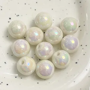 Close-up detail of white acrylic iridescent round beads showing macaron AB color and drilled hole.