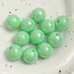 Detailed close-up shot of glossy green acrylic rainbow beads showcasing iridescent AB surface sheen.