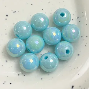 Close-up of light blue iridescent acrylic round beads for DIY jewelry and phone chains.