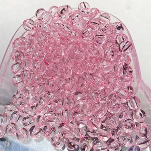 Detail de perles en acrylique transparent rose raye pour la fabrication de bijoux DIY.