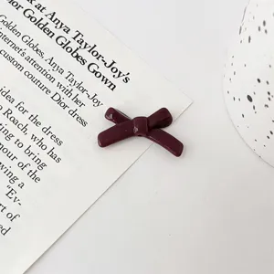 Close-up detail of burgundy bow bead, perfect for DIY bracelet making and jewelry accessories.