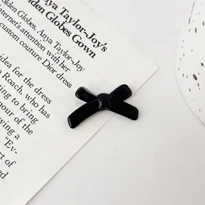 Black bow knot jewelry accessory detail shot, perfect for DIY crafts and charm bracelets.