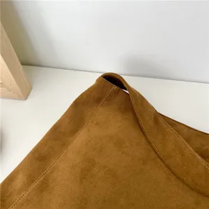 Brown suede tote bag detail showing fine texture and stitching workmanship, stylish minimalist.