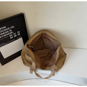 Large capacity casual tote bag interior detail showing multi compartments and storage pockets.