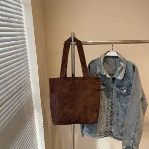 Detailed view of the brown corduroy tote bag showing its texture, capacity and dual straps.