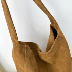 Brown faux suede slouchy hobo bag detail view showing soft texture and shoulder strap.