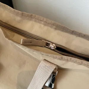 Detailed view of the casual canvas tote bag zipper and strap, showing durable design.