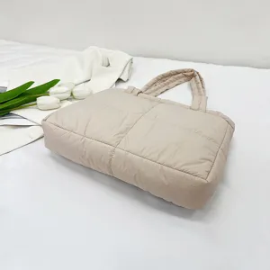 Closeup view of the soft quilted nylon tote bag showing detailed puffer texture and stitching.