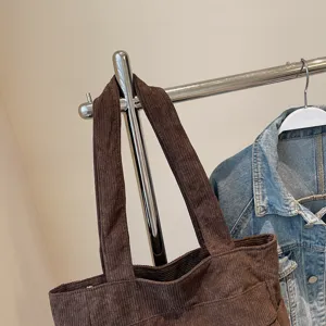 Detail view of brown corduroy tote bag, casual daily shoulder handbag showcasing texture and fabric.